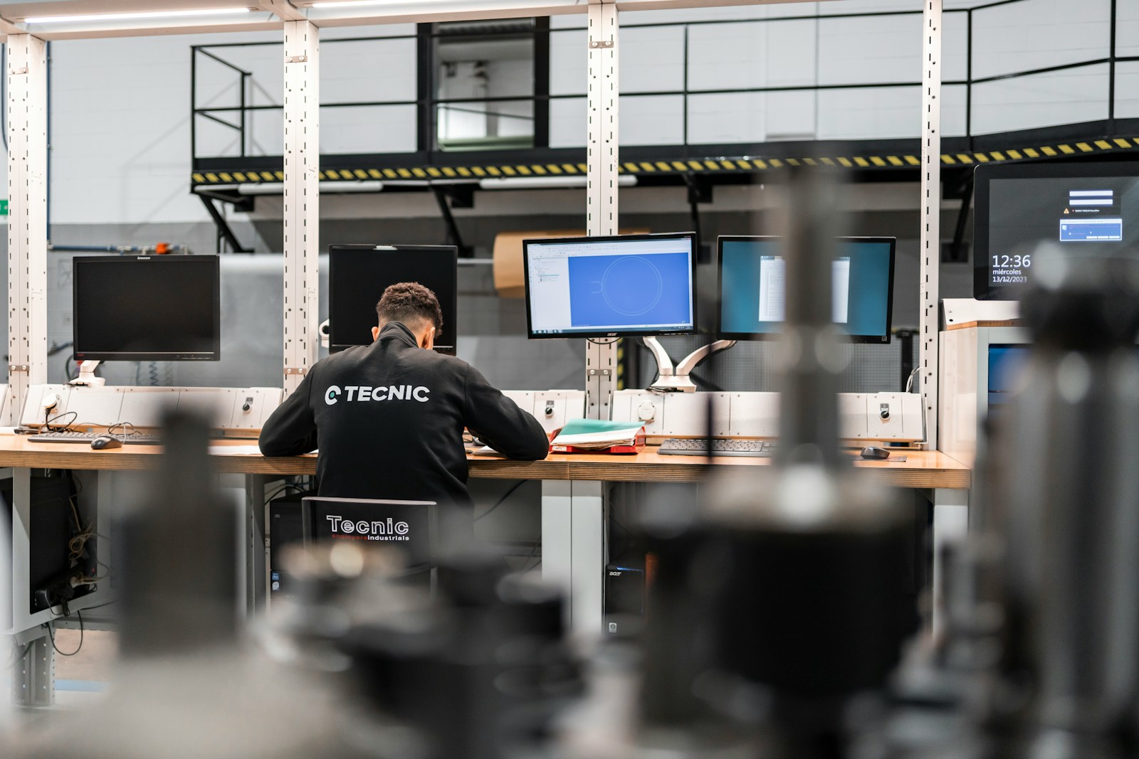 Tecnico specializzato al lavoro su più monitor di supporto